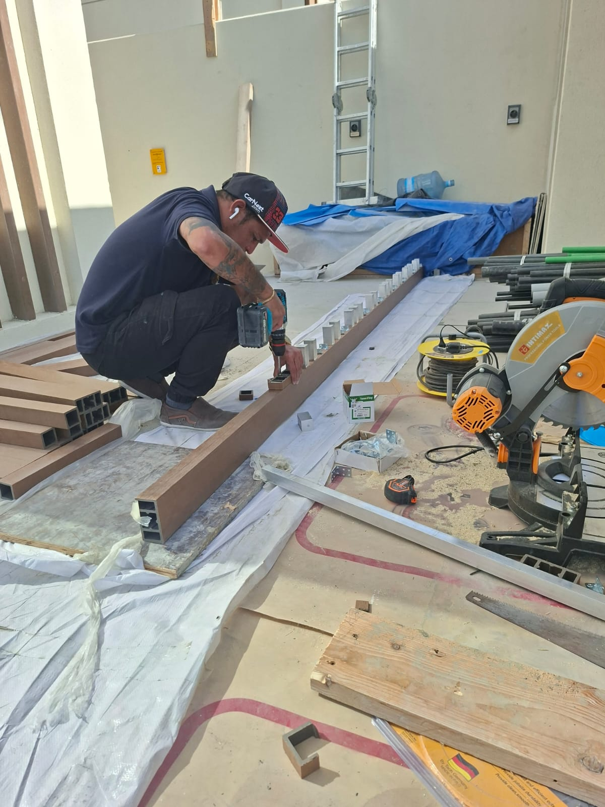 JBROS maintenance team cutting composite battens on-site for the pergola frame