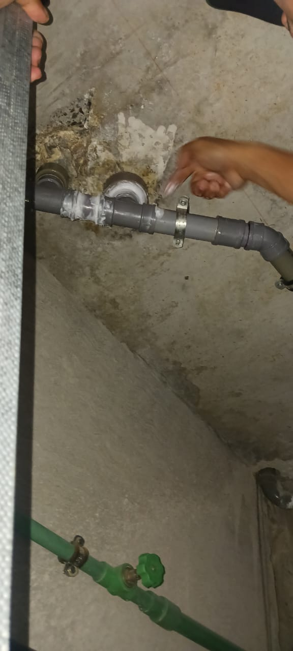 Repaired PVC waste pipe resealed and clamped in place