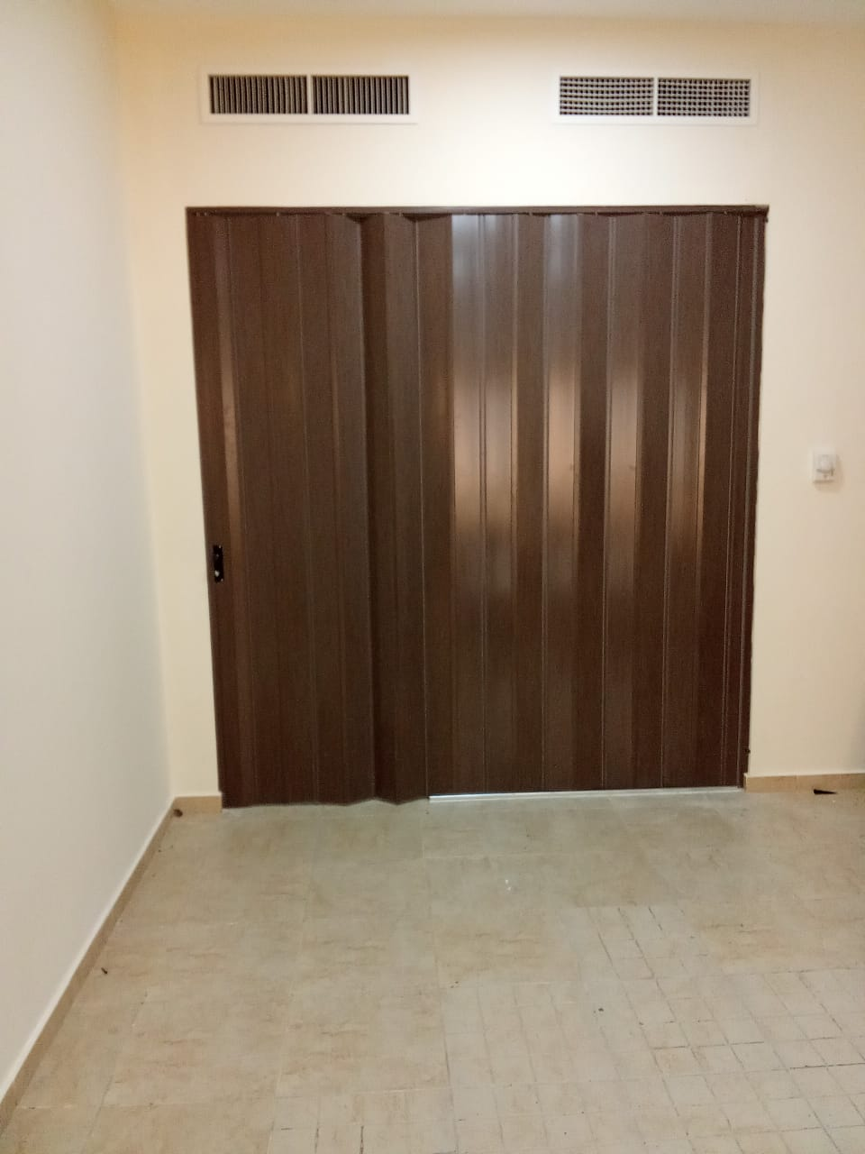 Installed folding partition door fitted cleanly within the room opening