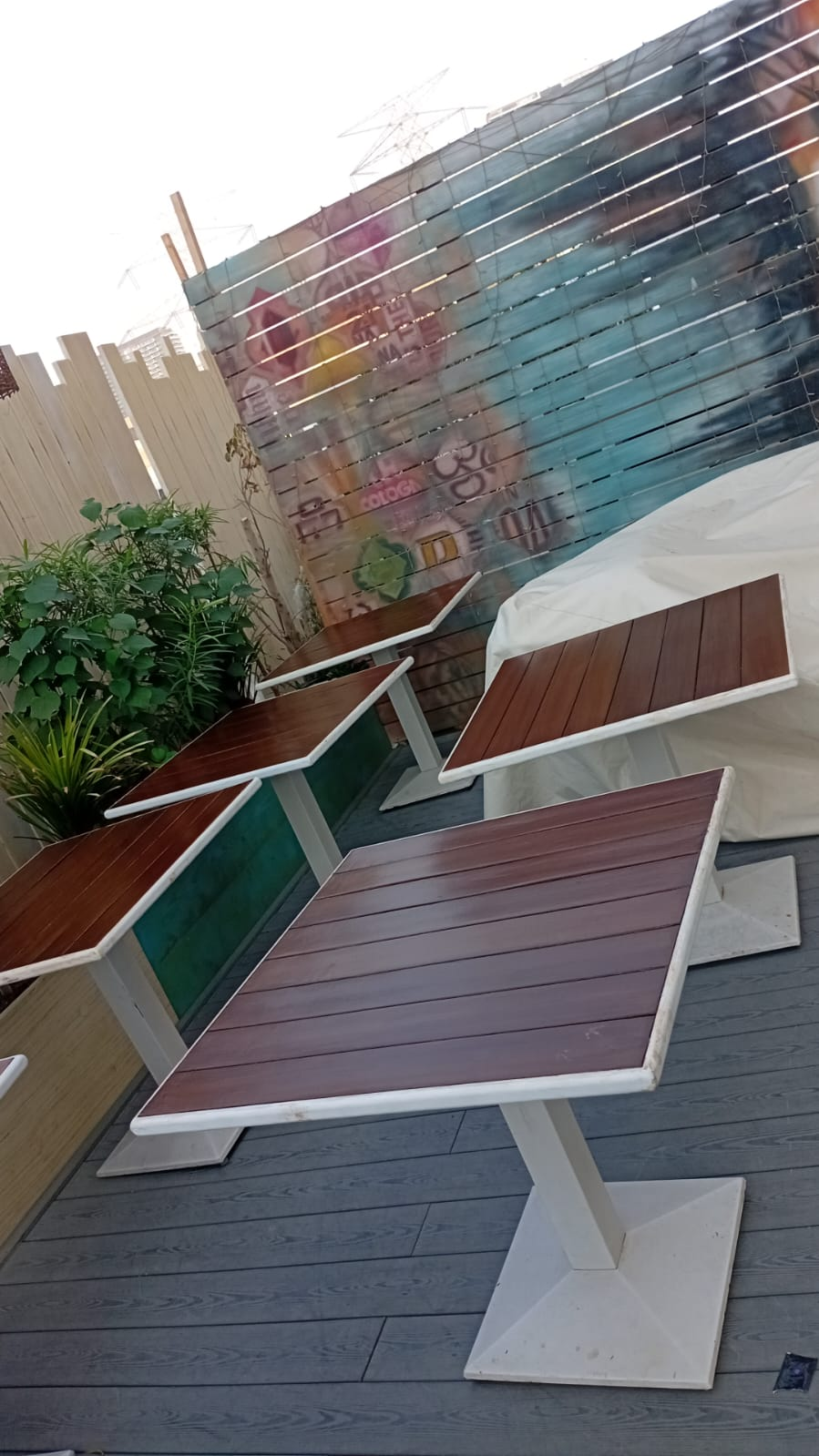 Multiple terrace tables restored and recoated across the seating area