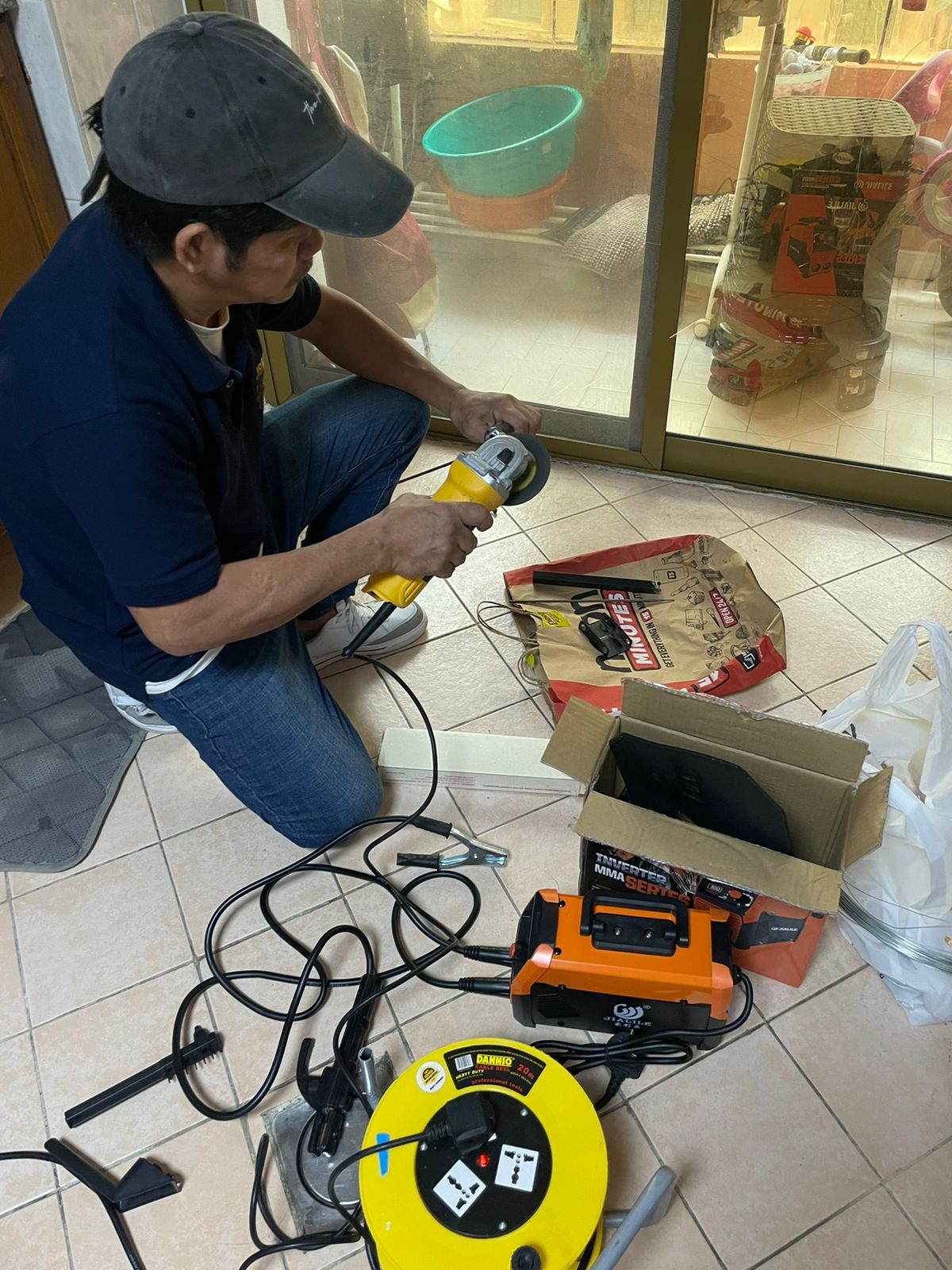 Handyman preparing an angle grinder for door-track adjustment work