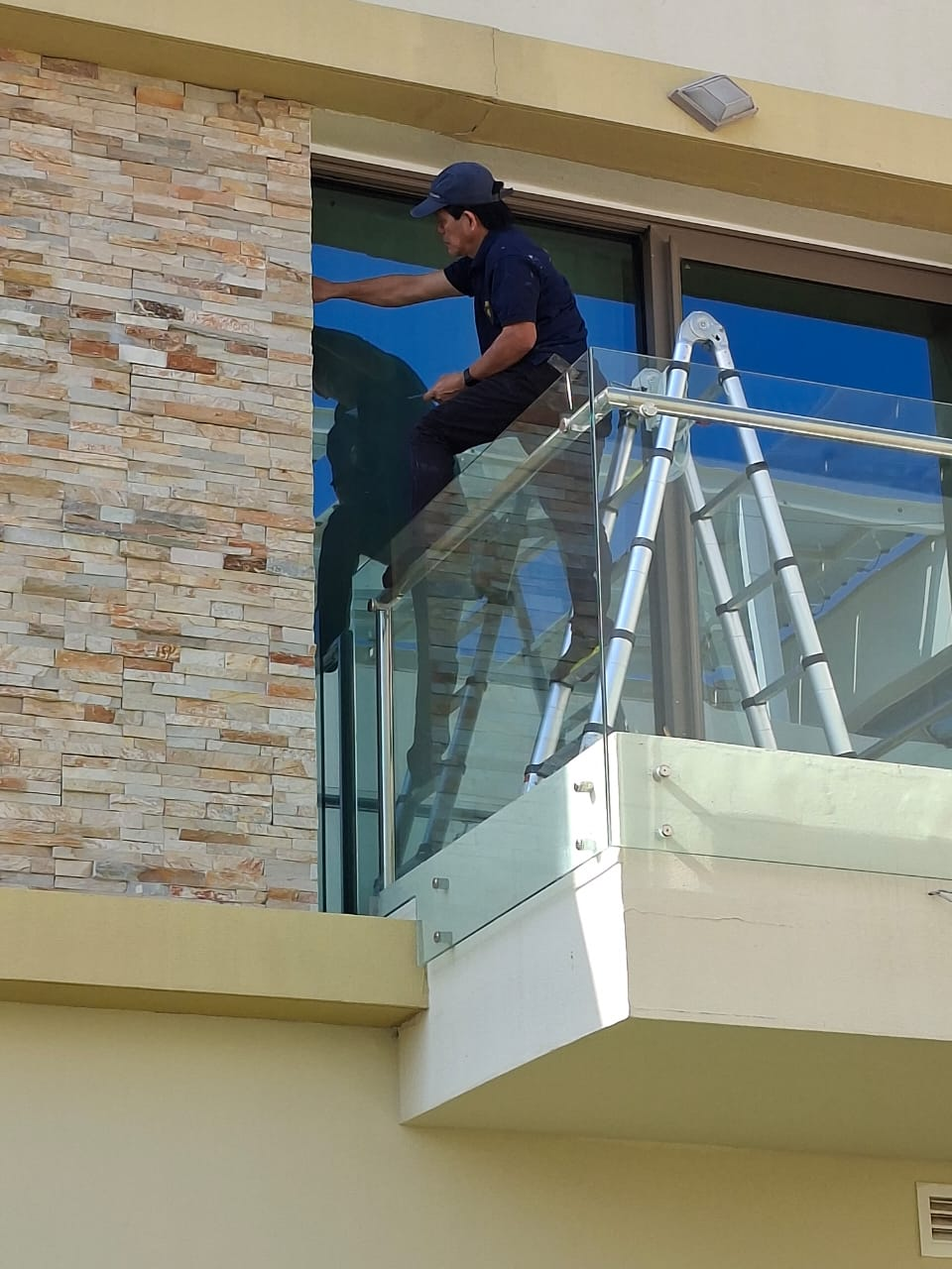High-level exterior crack repair and finishing work from the balcony edge