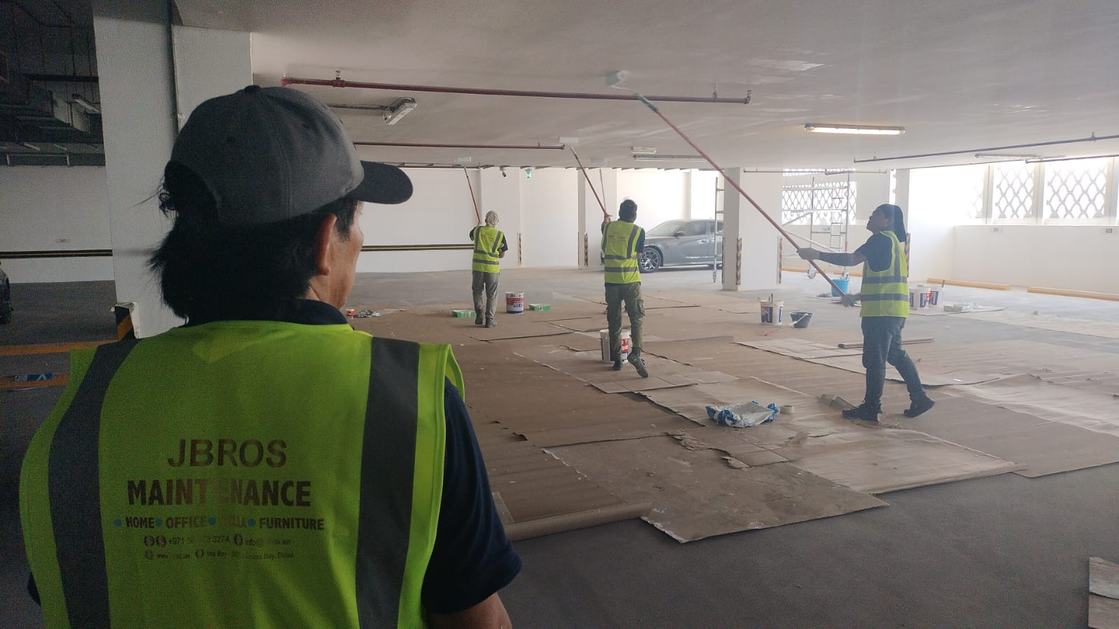 JBROS crew rolling ceiling coats across the parking deck
