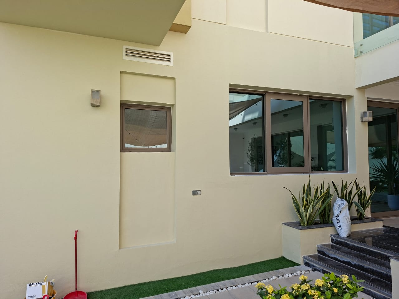 Completed exterior facade repaint with crisp finish around windows and planter