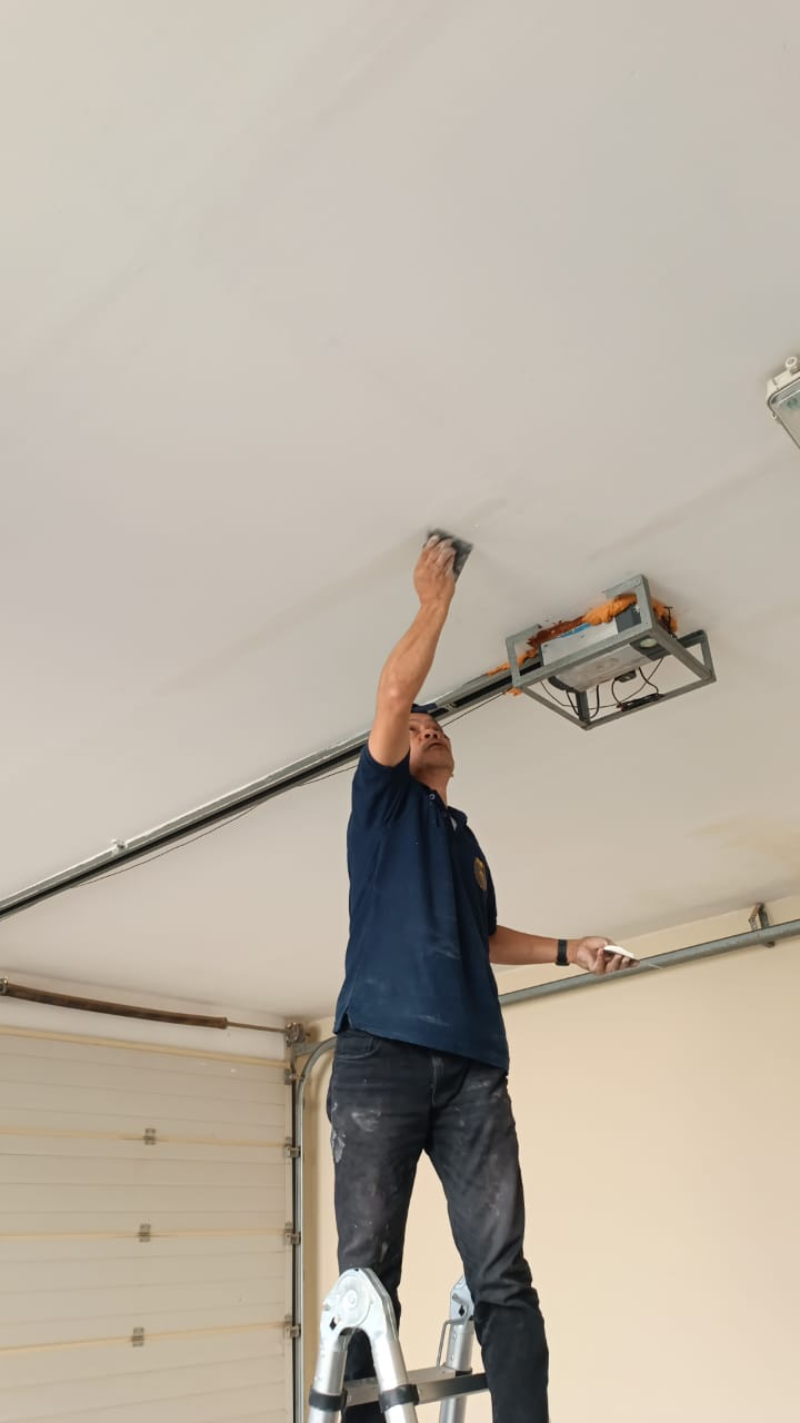 Garage ceiling patched and sanded around the motor housing before finish coat
