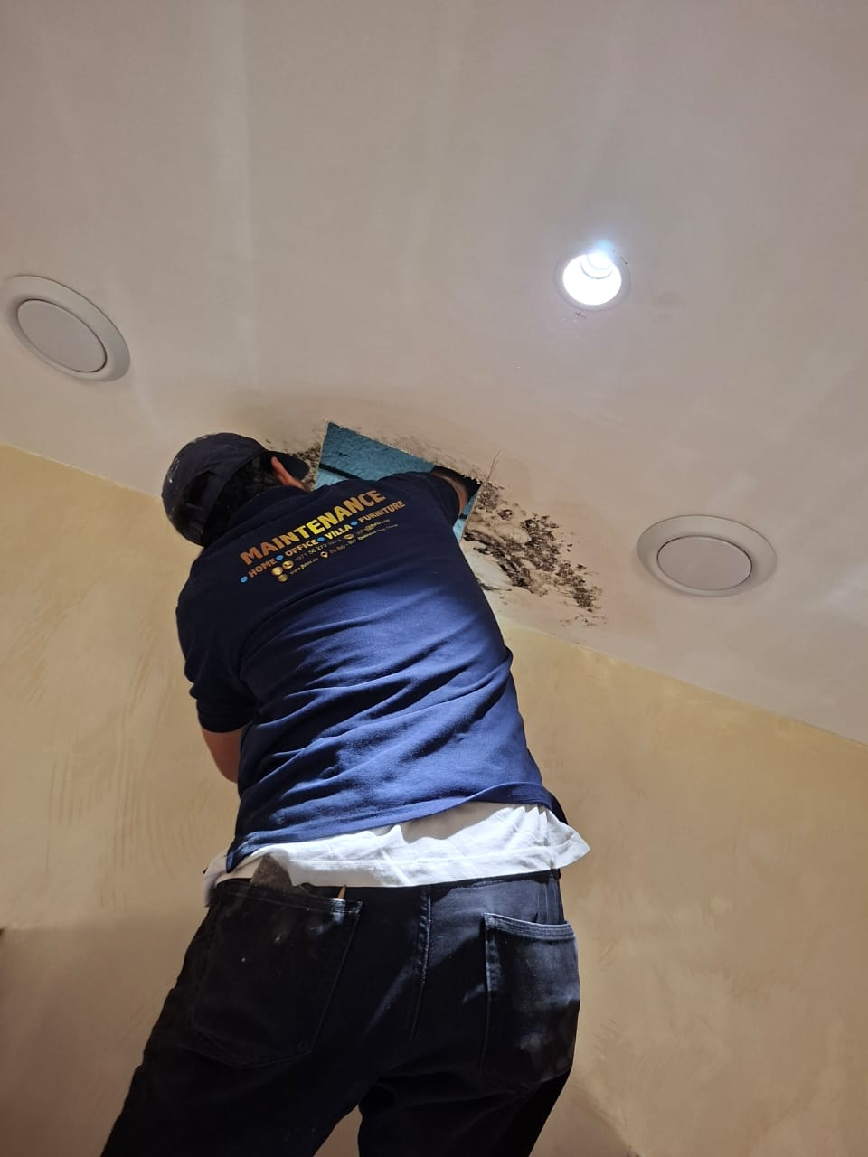 Opening ceiling access to repair moisture damage before repainting the interior finish