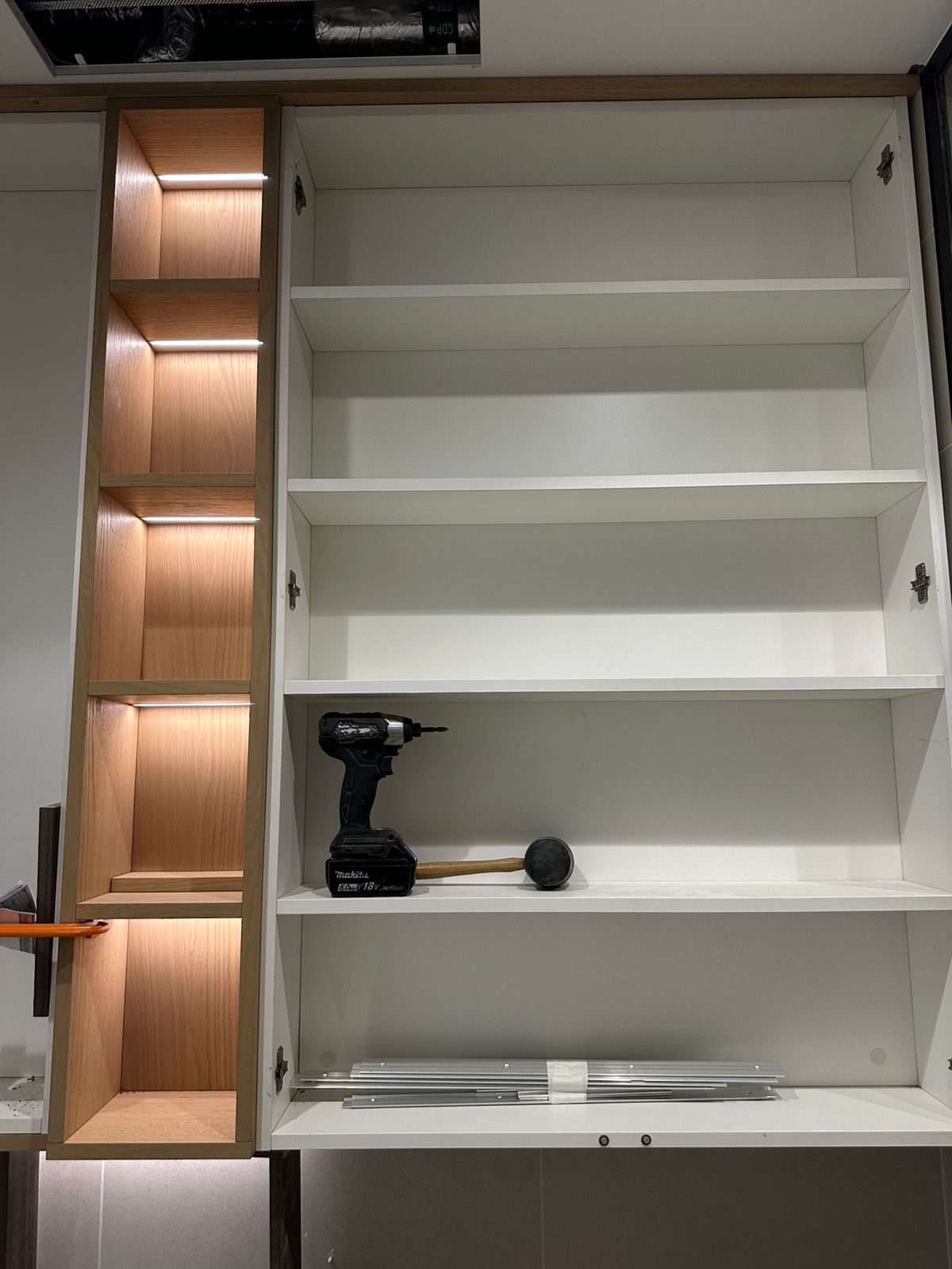 Bespoke illuminated shelving and cabinet installation nearing completion