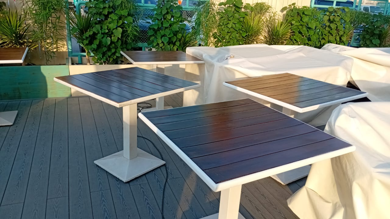 Refinished outdoor café tables with renewed wood-tone tops